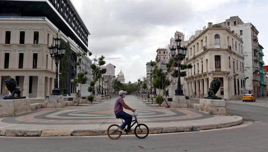 Un joven en bicicleta pasa por el paseo del Prado